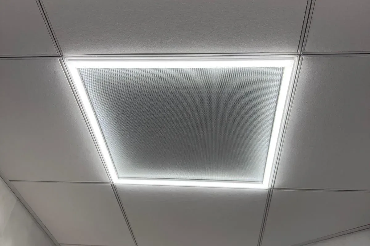 Drop ceiling with a flush LED panel light installed by Innov Builders in a finished lower-level room