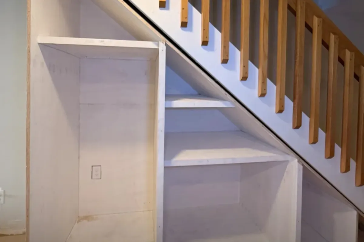 Built-in entertainment wall with floating shelves and cabinetry around a fireplace in Lynnfield, MA