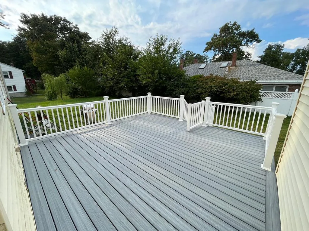 Wide gray composite decking with white railing installed in Wakefield, MA