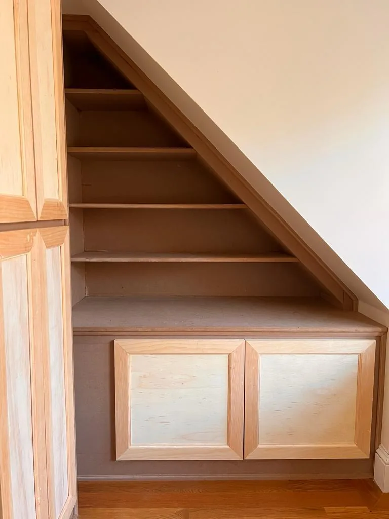 Custom under-stair built-in shelving and cabinets in a Wakefield MA home by Innov Builders